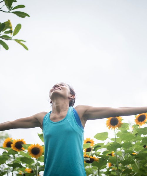 mujer-hermosa-aumento-manos-campo-girasoles-verano